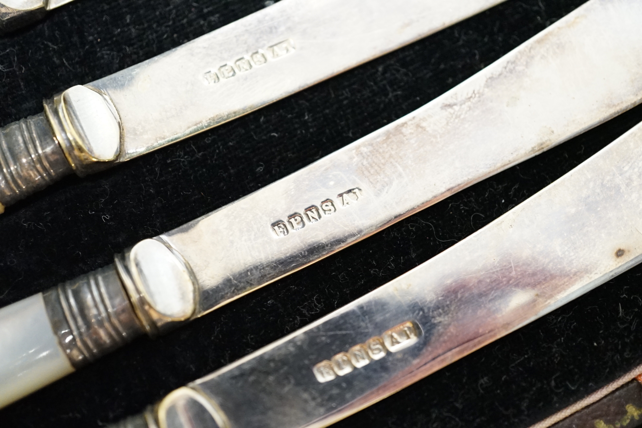 A George V silver mounted five piece dressing table set, two Georgian silver punch ladles and cased tea knives.